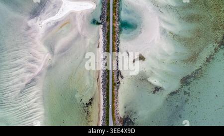 Drone aérien vue de haut en bas des marées peu profondes avec une eau turquoise envoûtante créant des formations de vagues naturelles et des textures sablonneuses divisées par des caus Banque D'Images