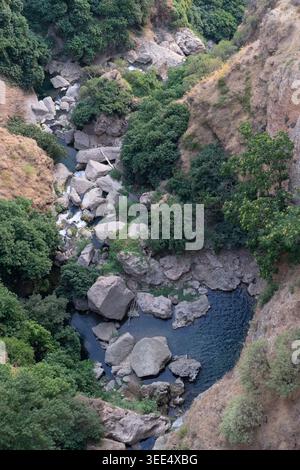 Vue sur le Rio Grande depuis le pont historique Puente Nuevo coulant à travers une gorge rocheuse avec des rochers et une végétation luxuriante Banque D'Images