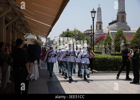 BANGKOK, THAÏLANDE-APR 5, 2026 : gardes royaux pratiquant la marche dans le palais, touristes prenant des photos, vue de face, Wat Phra Kaew. Banque D'Images