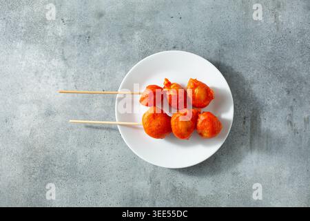 Une vue de haut en bas de quelques brochettes kwek kwek, sur une assiette. Banque D'Images