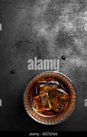 Cocktail de whisky vue de dessus avec de la glace sur fond noir foncé Banque D'Images