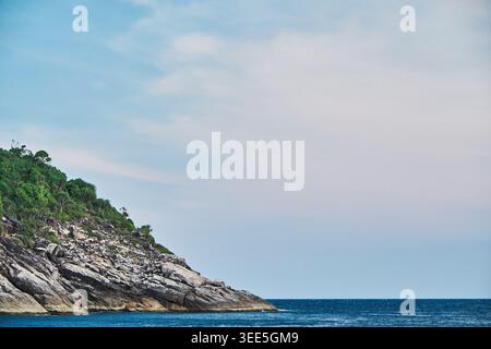 scène de paysage de rive rocheuse d'un bord de conner d'une petite île dans une mer bleue profonde dans un ciel bleu nuageux. Banque D'Images
