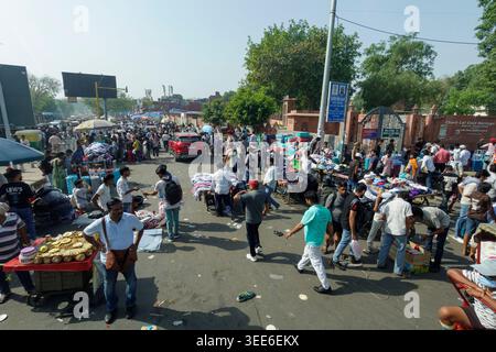 Scène de rue bondée dans Old Delhi Inde avec des gens faisant du shopping à un marché en plein air pendant une journée ensoleillée Banque D'Images