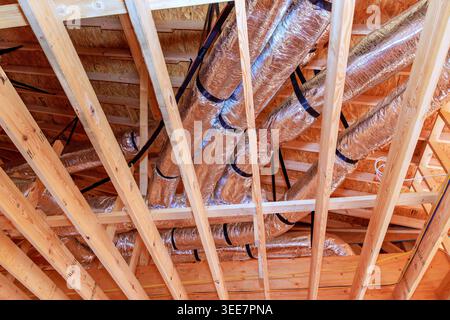 Des gaines sont installées dans un bâtiment avec des poutres en bois pendant la construction du système de chauffage, ventilation et climatisation Banque D'Images