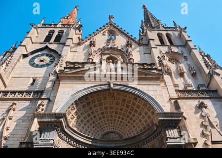 Lyon, France - 12 mai 2026 : façade de l'église Saint-Nizier avec des tours asymétriques, une flèche gothique et un portail à caissons Renaissance. Banque D'Images