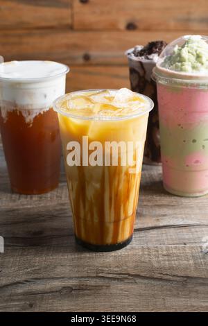 Une vue d'un thé aux fruits de mangue de sucre brun, parmi plusieurs autres boissons de thé au lait. Banque D'Images