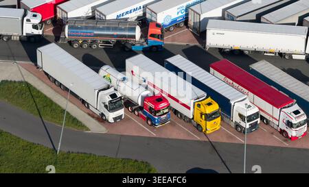 BANT, pays-Bas - 23 avril 2026 : vue aérienne de divers semi-camions et remorques stationnés dans une aire de repos désignée ou un centre logistique par temps clair Banque D'Images