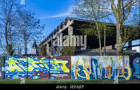 Mur de graffitis coloré près de la rivière Spree avec une architecture de style industriel en arrière-plan à Berlin-Kreuzberg, Allemagne. Street Art, mural. Banque D'Images