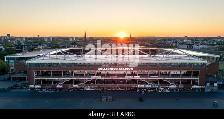 Hambourg, Allemagne - 1er mai 2026 : vue aérienne du Millerntor-Stadion au coucher du soleil avec l'horizon de la ville et les flèches de l'église en arrière-plan. Banque D'Images