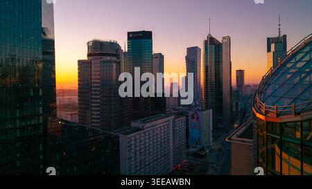 Varsovie, Pologne - 07 mars 2026 : vue aérienne de la ville moderne avec des gratte-ciels en verre reflétant la lumière dorée du coucher de soleil sur le paysage urbain Banque D'Images