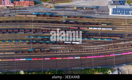 Prague, Tchéquie - 21 avril 2026 : vue aérienne de la gare de triage avec de nombreux trains de marchandises et wagons colorés sur plusieurs voies parallèles. Banque D'Images