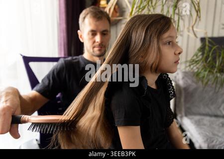 Gros plan du père brossant les cheveux de sa fille Banque D'Images