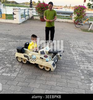 Les parents se joignent au plaisir en contrôlant leurs mini voitures childÕs radiocommandées dans le parc 30 Thang 4 sur la promenade principale de Chau Doc cityÕs, face au confl Banque D'Images