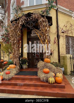 Entrée confortable de café d'automne décorée avec des citrouilles, des balles de foin et du maïs séché pour le festival des récoltes saisonnières Banque D'Images