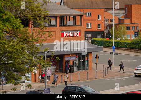 Boutique de supermarché Islande à Chester, Royaume-Uni, avec un bâtiment en briques rouges, des piétons sur le trottoir, et la vie urbaine dans la rue dans le Cheshire Banque D'Images