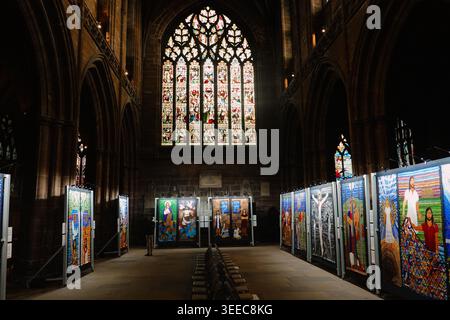 Vitrail vibrant et exposition d'art à l'intérieur de la cathédrale de Chester, Chester, Royaume-Uni, avec des expositions religieuses illuminées dans la nef Banque D'Images
