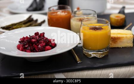 Hors-d'œuvre assortis, y compris salade de betteraves, gazpacho et autres petits plats, présentés pour la dégustation Banque D'Images
