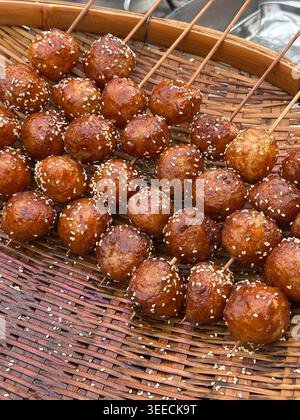 Brochettes de boulettes de riz gluantes sucrées au sésame frites recouvertes de sésame dans la rue de Chengdu, province du Sichuan en Chine Banque D'Images