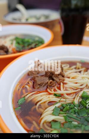 Soupe de nouilles de bœuf avec oignon de printemps et huile de piment du Sichuan (Hóng Yóu) servie dans un restaurant à Dujiangyan, province chinoise du Sichuan Banque D'Images