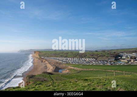 Freshwater Holiday Park sur la plage de Chesil près de Burton Bradstock montrant les maisons statiques avec l'entrée du port de West Bay et Golden Cap au loin. Banque D'Images