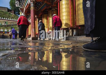 Pèlerins marchant autour des roues de prière Tagong, province du Sichuan, Kham Tibet, Banque D'Images