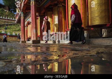 Pèlerins marchant autour des roues de prière Tagong, province du Sichuan, Kham Tibet, Banque D'Images