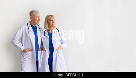 Professionnels de santé matures, hommes et femmes, posant ensemble en manteau blanc Banque D'Images