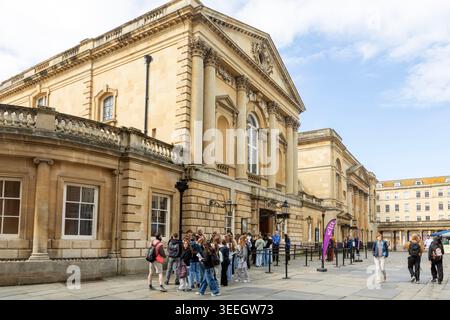 Groupe d'adolescents devant l'entrée des bains romains, cimetière de l'abbaye, ville de Bath, Somerset nord-est, Angleterre, ROYAUME-UNI Banque D'Images
