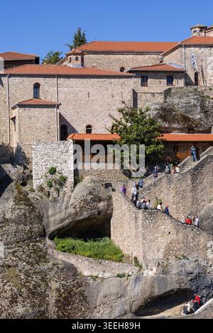 Météores, Grèce, 3 mai 2026. monastère de grande météoron construit sur un haut rocher de grès avec des touristes grimpant des escaliers de pierre sous un ciel bleu clair dedans Banque D'Images