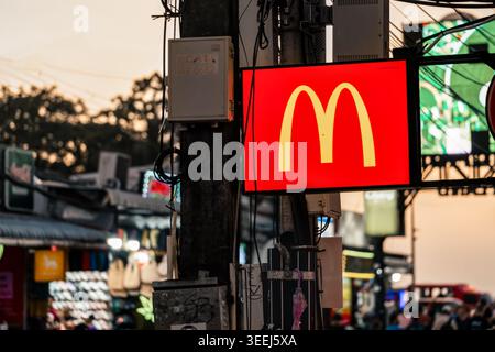 Phuket Thaïlande 29 11 2025 : enseigne McDonald's illuminée dans une rue de la ville à Patong pendant les heures du soir entouré de fils électriques, néons et Banque D'Images