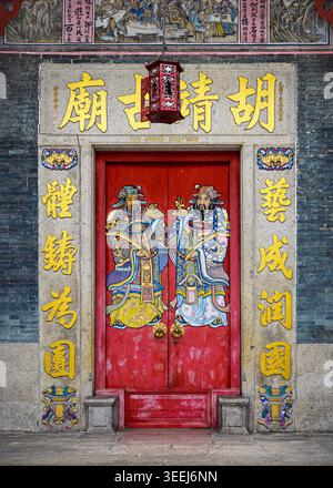 Vue de face symétrique d'une entrée de bâtiment traditionnel chinois avec portes doubles rouges et signalisation en or, George Town, Penang, Malaisie Banque D'Images