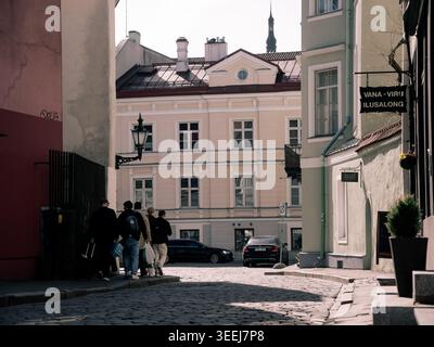 Les piétons marchent le long d'une rue pavée devant des bâtiments colorés dans la vieille ville de Tallinn, en Estonie, au printemps Banque D'Images