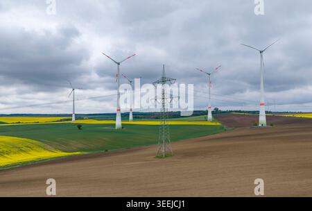 08 mai 2026, Saxe-Anhalt, Eisleben : des éoliennes tournent derrière une ligne à très haute tension de 380 kV près de Volkstedt. Photo : Jan Woitas/dpa Banque D'Images