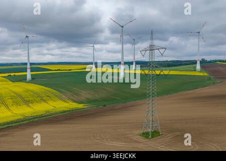 08 mai 2026, Saxe-Anhalt, Eisleben : des éoliennes tournent derrière une ligne à très haute tension de 380 kV près de Volkstedt. Photo : Jan Woitas/dpa Banque D'Images