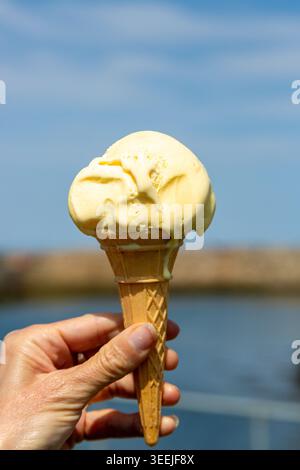 Gros plan d'une glace fondante à la vanille dans un cornet de gaufre traditionnel Banque D'Images