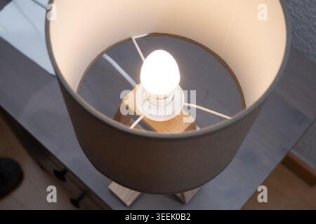 Vue rapprochée d'une ampoule incandescente à l'intérieur d'un abat-jour en tissu Banque D'Images