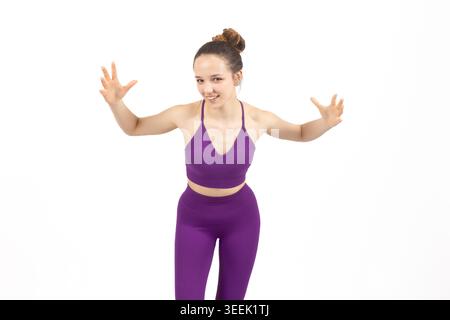 Femme dans l'équipement d'entraînement violet tout en se tenant debout et posant pour le concept de fitness dans pr Banque D'Images