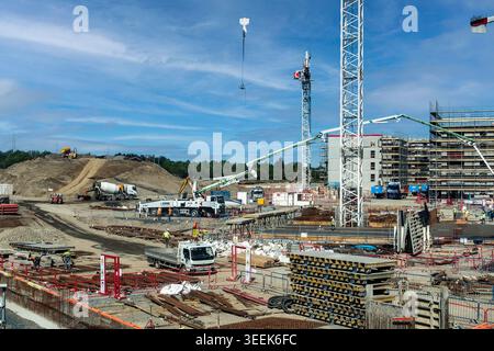 Grand chantier de construction à Dublin, en Irlande, avec grues hautes, camions à pompe à béton et ouvriers développant un nouveau complexe de bâtiments résidentiels. Banque D'Images