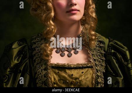 Gros plan de la jeune femme portant une robe historique et des bijoux, posant pour le concept de portrait d'époque. Idéal pour le marketing patrimonial, la conception de costumes, la promotion de musées Banque D'Images
