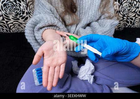 Infirmière ou médecin en gant bleu faisant injection médicale avec seringue à un enfant dans des vêtements décontractés de gros plan Banque D'Images