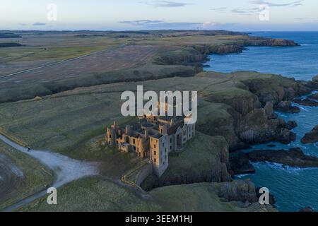 Vue aérienne des ruines historiques du château de Slains perché sur des falaises escarpées surplombant la mer du Nord au coucher du soleil, Cruden Bay, Écosse, Royaume-Uni. Banque D'Images