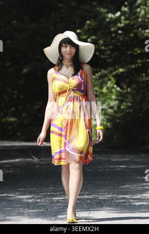 Une belle fille portant des dres d'été et un grand chapeau dans le pays Banque D'Images