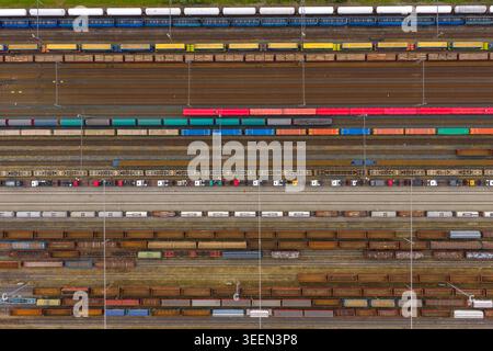 Vue aérienne de trains de marchandises colorés et de wagons sur plusieurs voies dans une gare de triage à Breclav, région de Moravie du Sud, Tchéquie. Banque D'Images