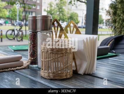 Table en bois de salière et poivrière, récipient de sel, pot d'épices, shakers de bouteille de poivre noir, moulin d'assaisonnement, condiments mis sur la table du restaurant Banque D'Images