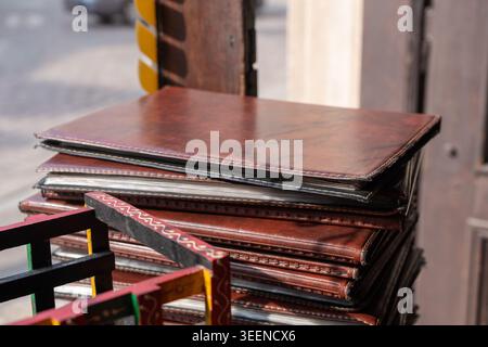 Pile de menus de papier de restaurant, livres de menu dans la pile de couvertures de cuir avec l'accent sélectif sur le fond flou Banque D'Images