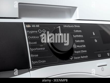 Vue rapprochée de la molette de commande et de l'écran du lave-linge. Panneau d'appareil à chargement frontal avec options de programme. Détail de l'équipement de blanchisserie domestique pour Clea Banque D'Images