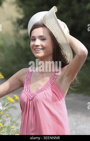 Une belle fille en grand chapeau d'été dans le pays Banque D'Images