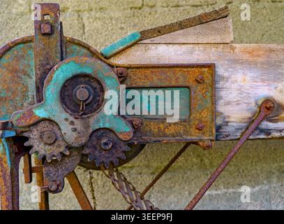 Gros plan des engrenages industriels vintage rouillés et des pièces mécaniques sur la vieille poutre en bois, fond d'ingénierie rustique Banque D'Images
