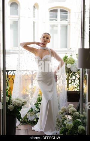 Mariée élégante debout sur un balcon décoré, se préparant pour son jour de mariage, mettant en valeur la mode et la cérémonie de mariage Banque D'Images