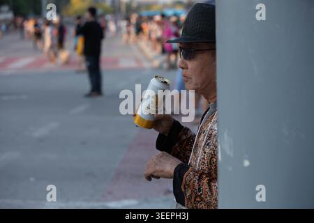 CHIANG mai, THAÏLANDE-APR 15, 2026 : touriste masculin buvant de la bière à Can, fête de l'eau de Songkran en Thaïlande, gros plan, Nimman. Banque D'Images